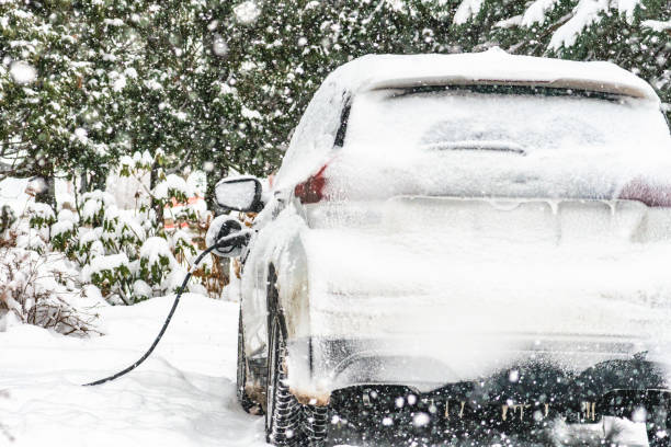 In Saint-Hugues, Quebec, Canada, Diring a snowfall an electric car is covered with snow. The car is the Chevrolet Bolt. The vehicle is charging. A lot of snow covers the car.