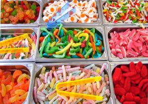 small bins of gummy worms and other candies
