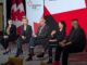 5 Panelists seated on stage with Canada's Podium sign behind him.